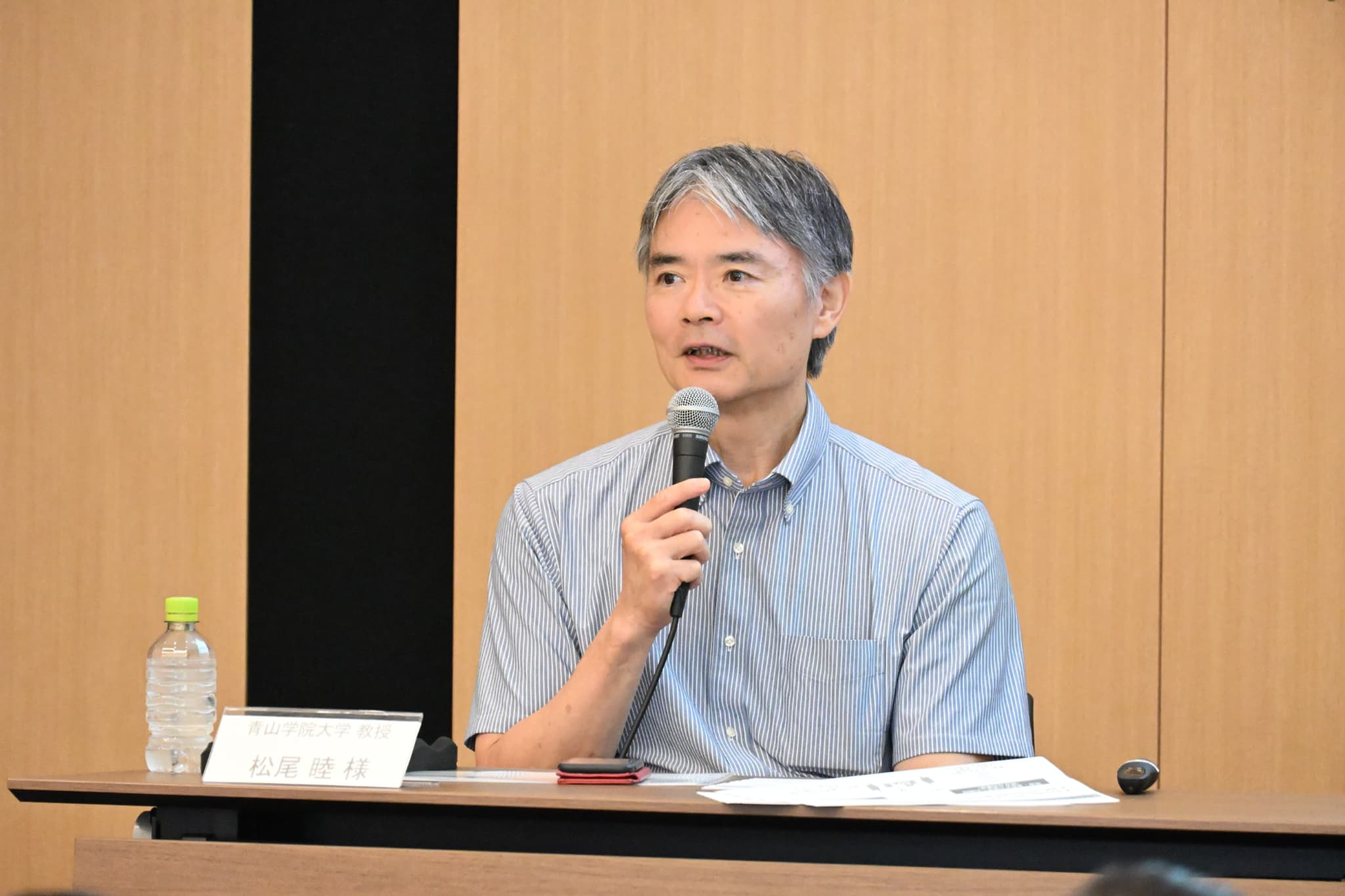 第1部でマイクを持って話す、青山学院大学の松尾 睦 教授